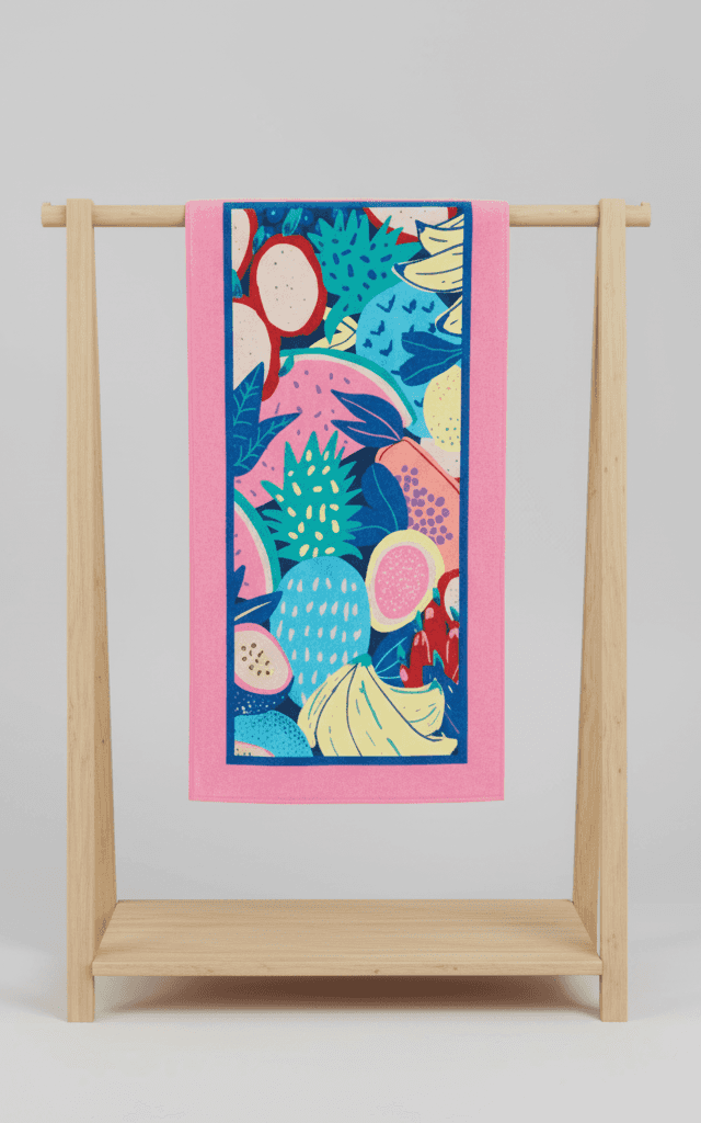 エキゾチックなフルーツとブルーボーダーを特徴とする鮮やかなグラフィックトロピカルフルーツパターンのピンクタオル